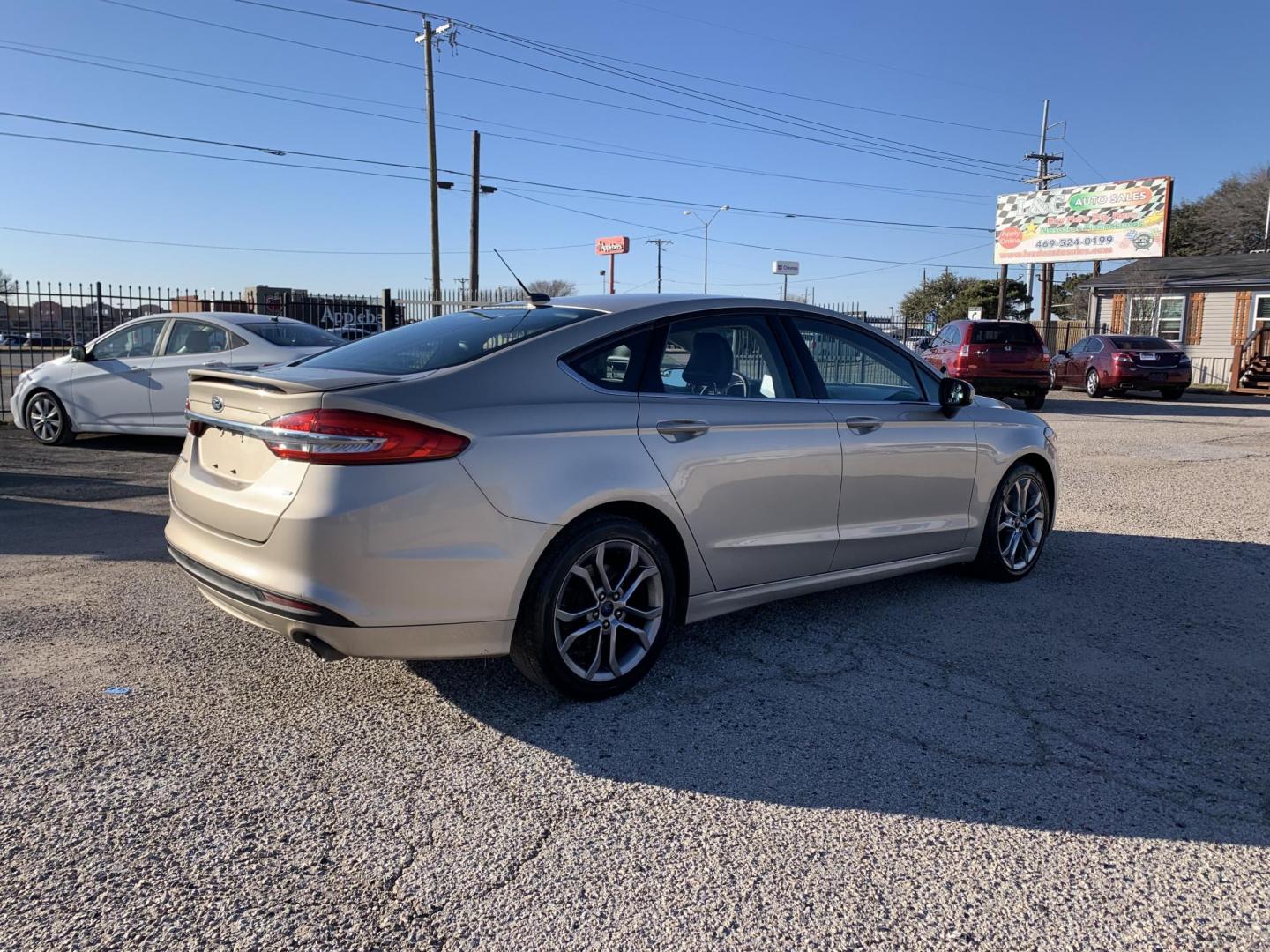 2017 Gold /Black Ford Fusion SE (3FA6P0H7XHR) with an 2.5L L4 DOHC 16V engine, AUTOMATIC transmission, located at 1830 North Belt Line Road, Irving, TX, 75061, (469) 524-0199, 32.834373, -96.993584 - Photo#6